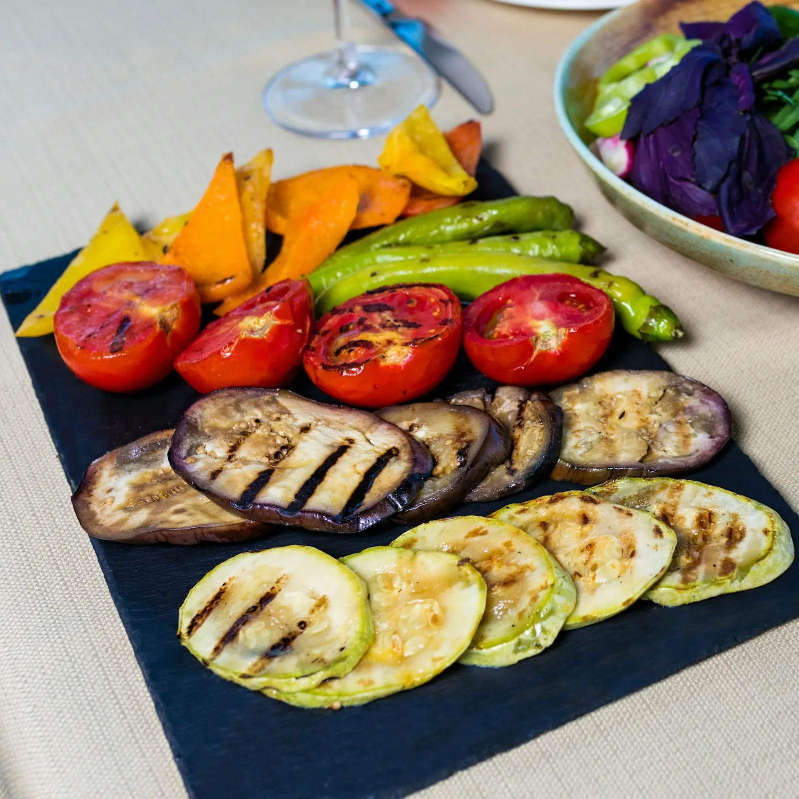 Grilled eggplant, zucchini, tomatoes and peppers on a slate board